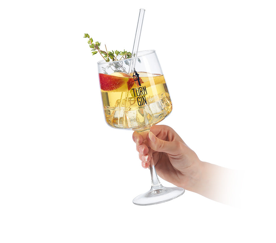 Gin Cocktail mit Eiswürfeln und Apfelscheiben im TURM GIN Glas gehalten von einer Hand.