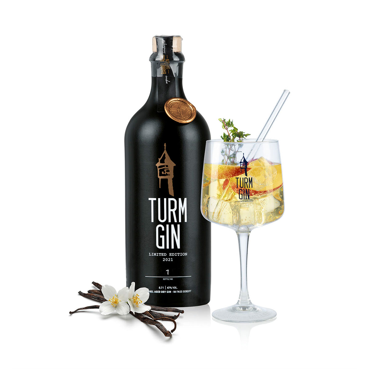 Die schwarze Flasche der TURM GIN Limited Edition 2021, daneben Vanille und ein fertiger Gin-Cocktail vor weißem Hintergrund.