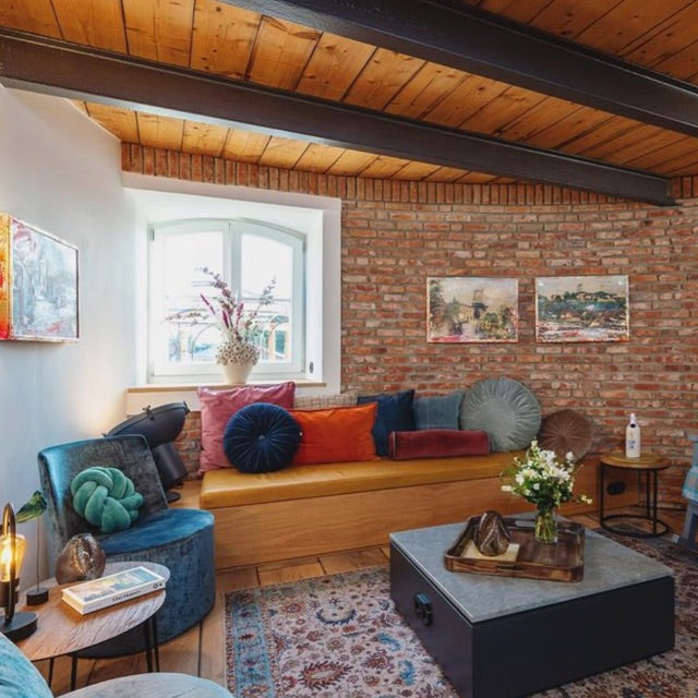 Einblick in das Hotelzimmer vom Wasserturm Bad Segeberg auf eine mit Kissen belegte Sitzecke.